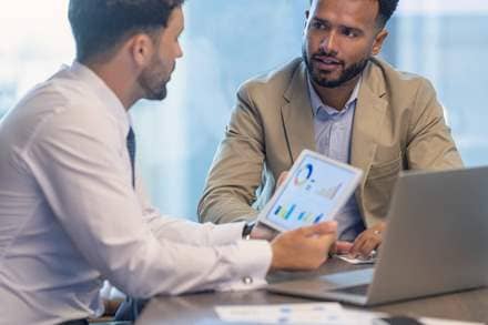 two people discussing investment charts