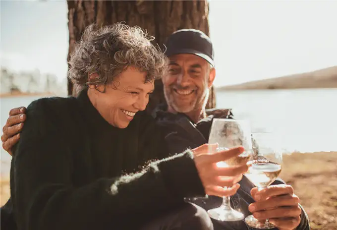 Retired couple enjoying their financial freedom with drinks