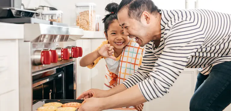 father and daughter cooking talking about life insurance