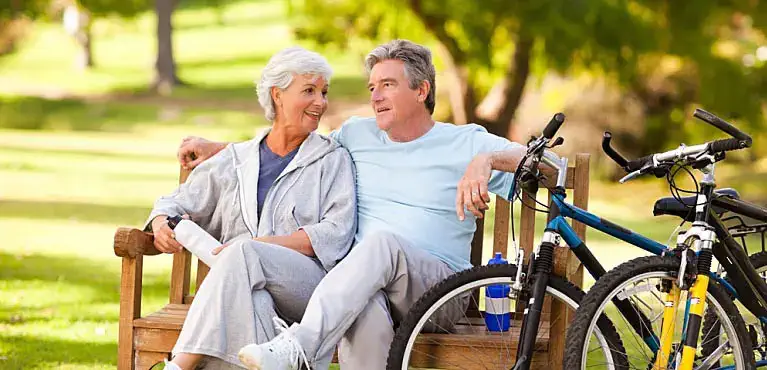 senior couple knowledgeable about the difference between medicare vs medicaid walking on the beach