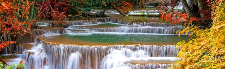 Cascading waterfalls surrounded by vibrant autumn colors.