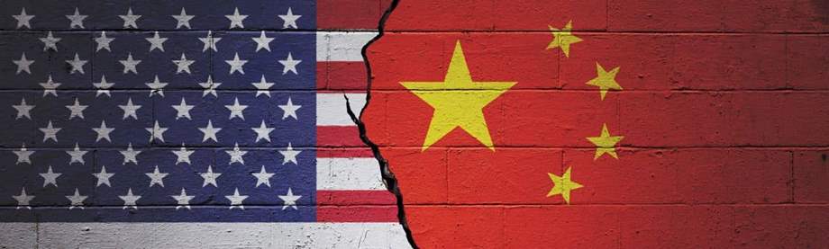 Cracked brick wall painted with an American flag on the left and a Chinese flag on the right.